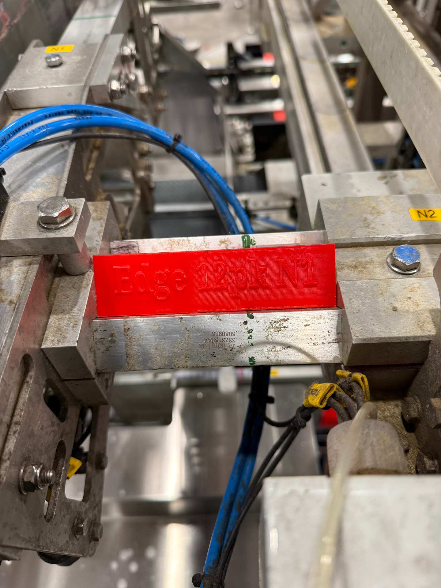 Red 3D-printed jig fixture on production equipment